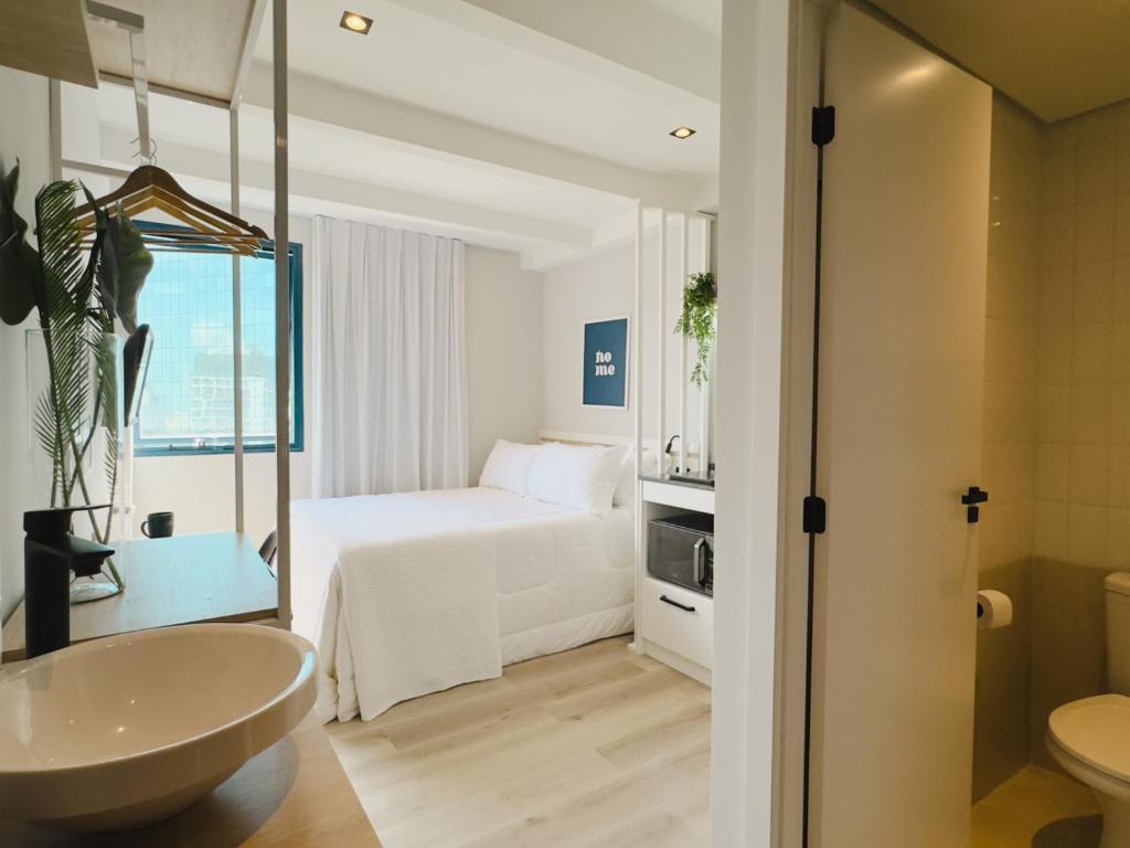 a bathroom with a bedroom with a bed and a sink at Apê Pátio Paulista in São Paulo