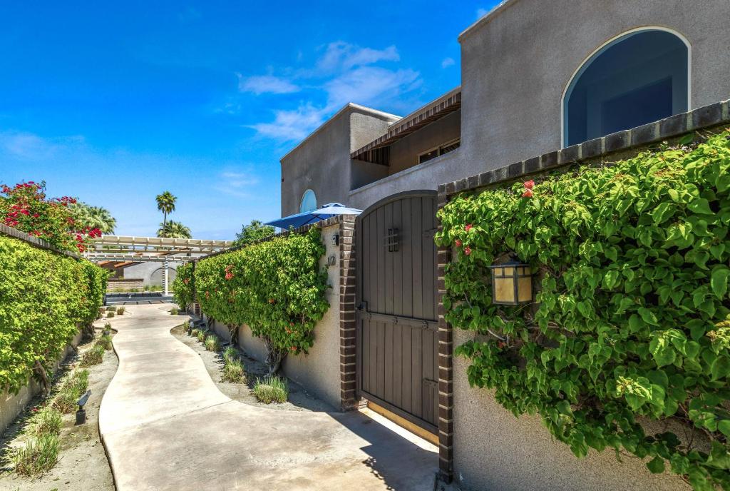 a house with a gate and ivy at Villa del Sol Montana - A Ryson Property in Palm Springs