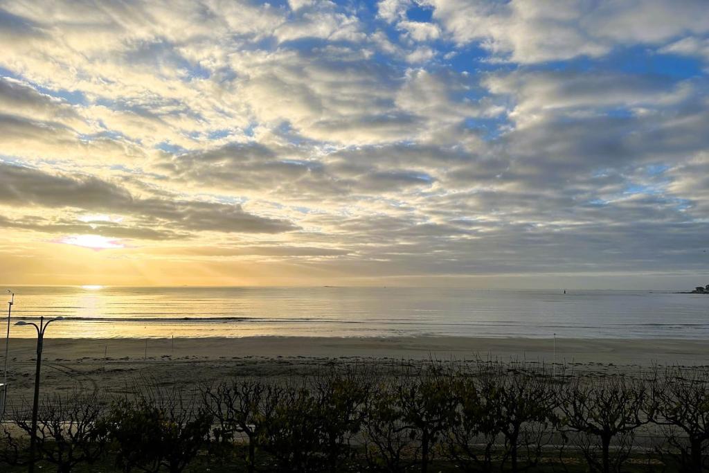 - une plage avec un ciel nuageux et l'océan dans l'établissement Family cocoon on the seafront, à La Baule