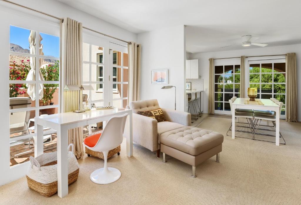 a living room with a table and a couch and a desk at Chic Downtown Bungalow - A Ryson Property in Palm Springs