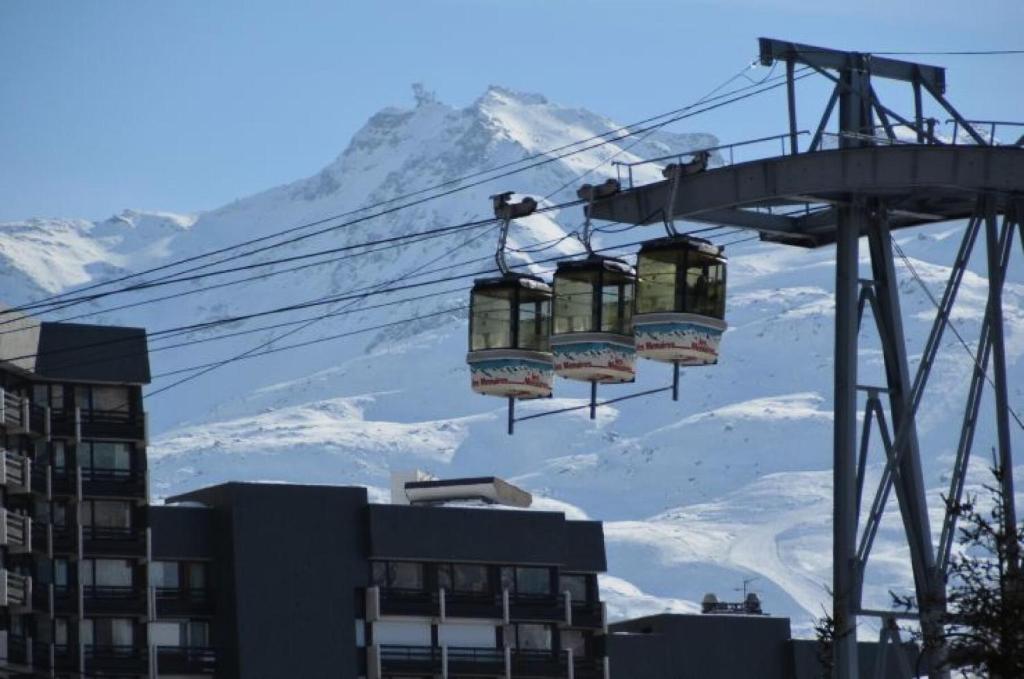 a ski lift in front of a snow covered mountain at Résidence Villaret - Studio pour 4 Personnes 194 in Les Menuires