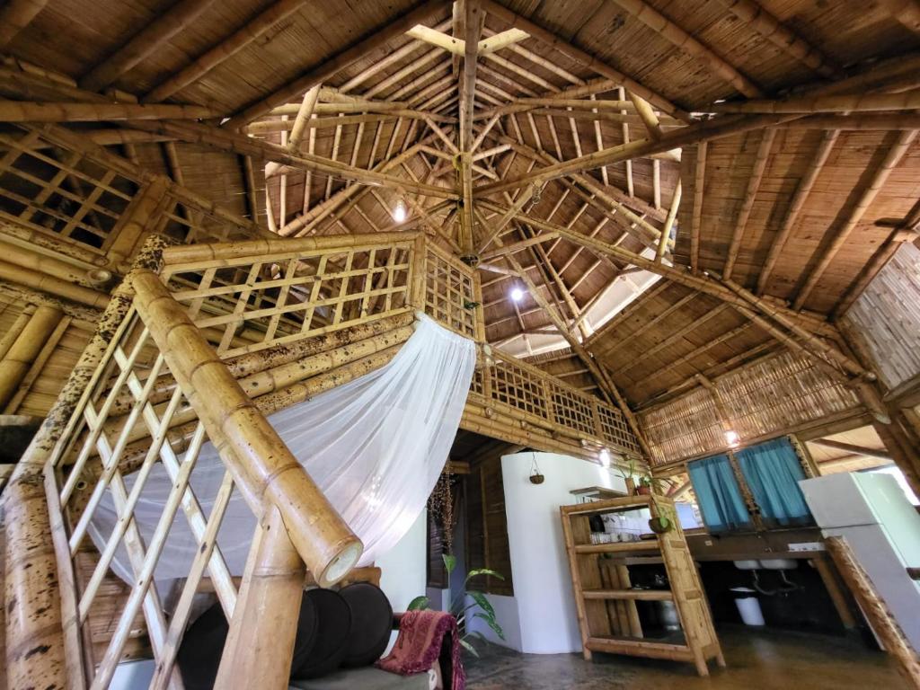 Cama en habitación con techo de madera en Eco-Lodge Deseo Bamboo en Santa Catalina