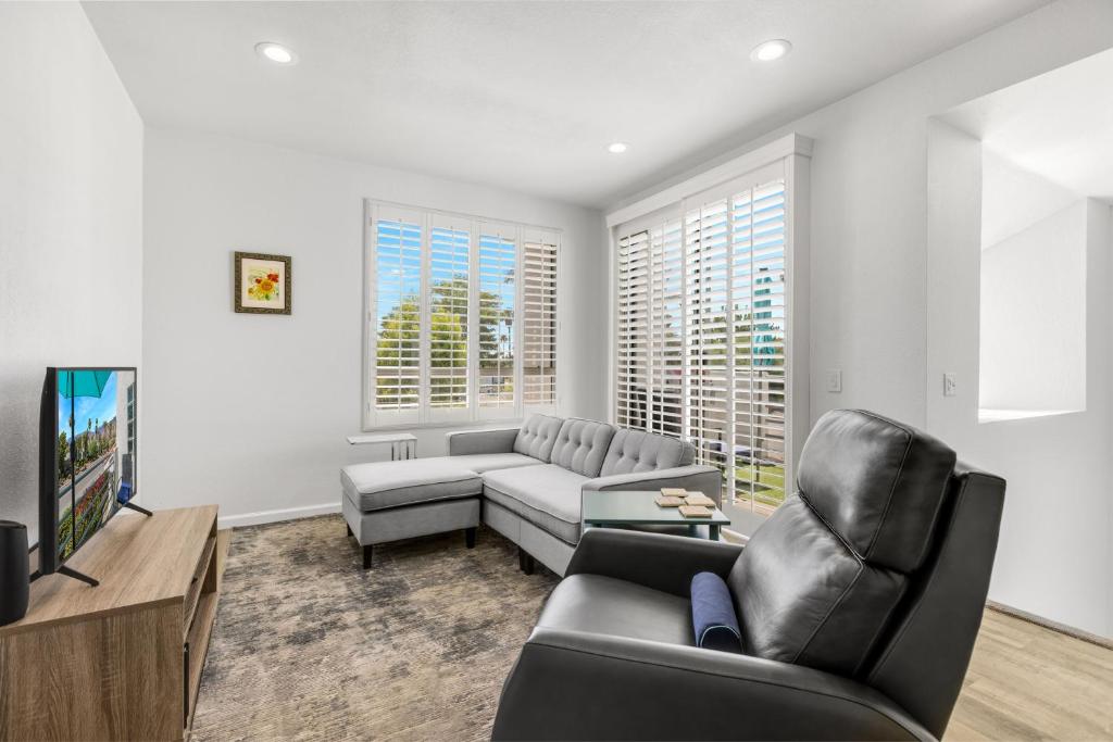 ein Wohnzimmer mit einem Sofa und einem TV in der Unterkunft Modern & Uncluttered - A Ryson Property in Palm Springs