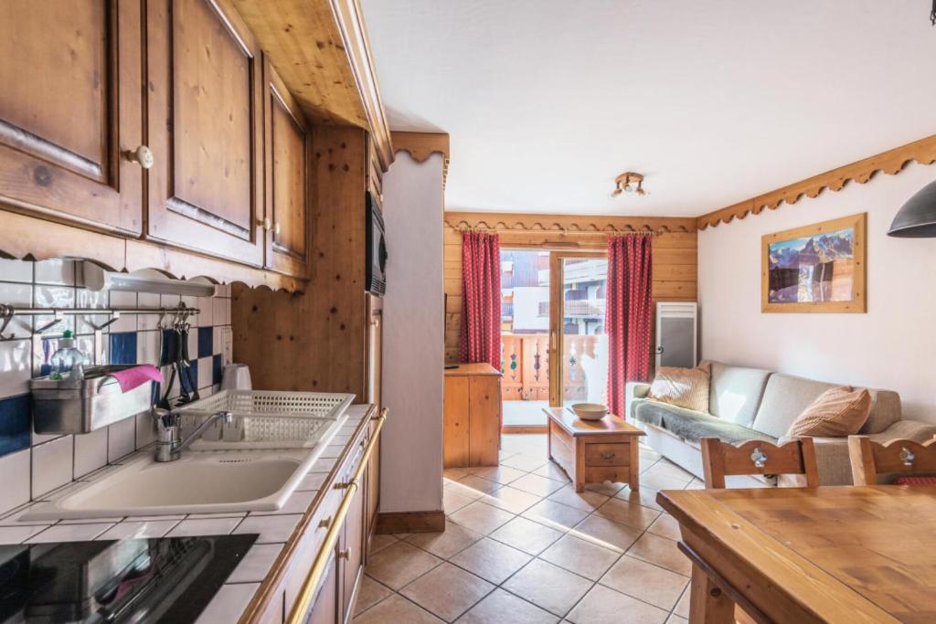eine Küche mit Spüle und ein Wohnzimmer in der Unterkunft Résidence Les Fermes du Soleil - maeva Home - Appartement 3 pièces 6 personnes Sélection MAE-1439 in Les Carroz d'Araches