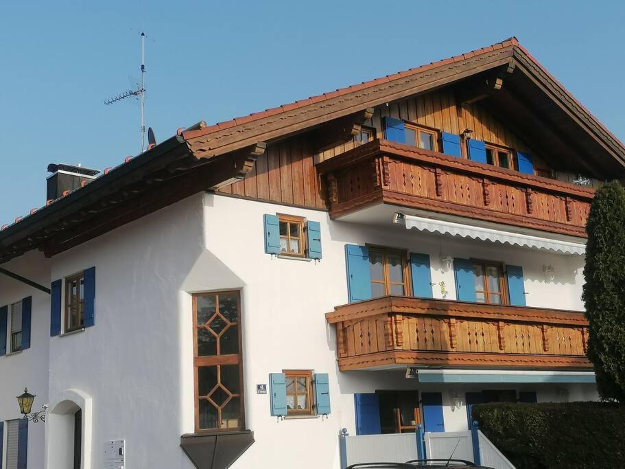 um edifício com varandas de madeira em cima em Ferienwohnung Lechsee em Lechbruck
