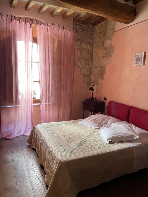 a bedroom with a bed and a window at Osteria Del Borgo B&B in Montepulciano