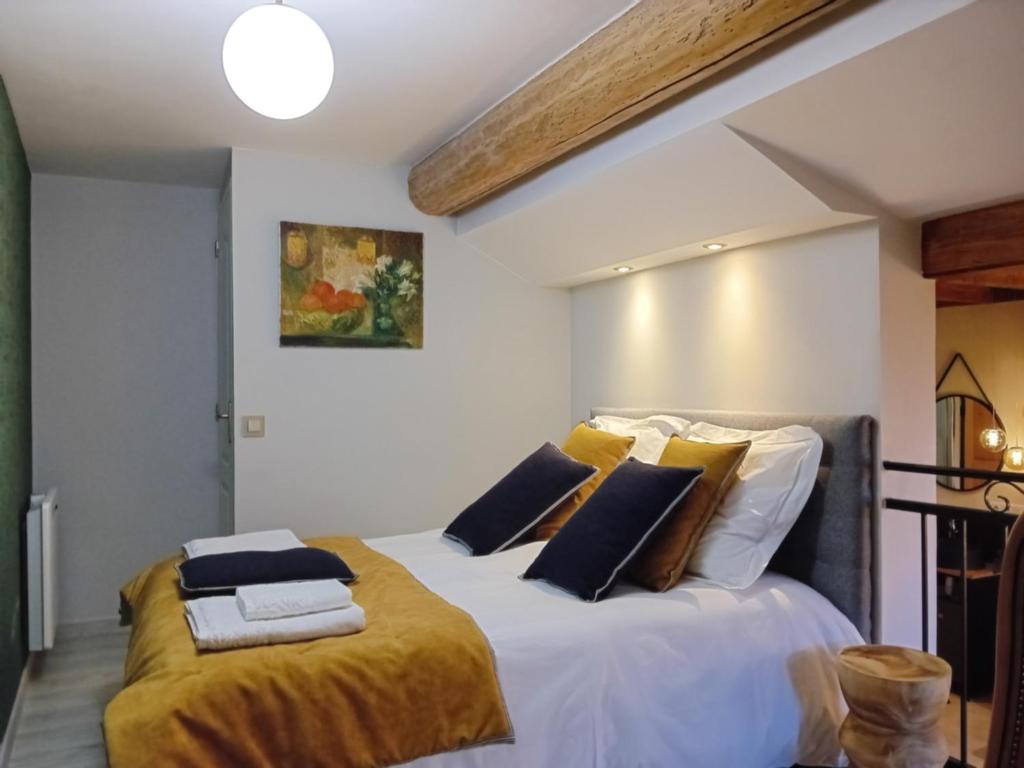 a bedroom with a large bed with yellow and white pillows at La porte chamarrée... in Saint-Nicolas-de-la-Grave