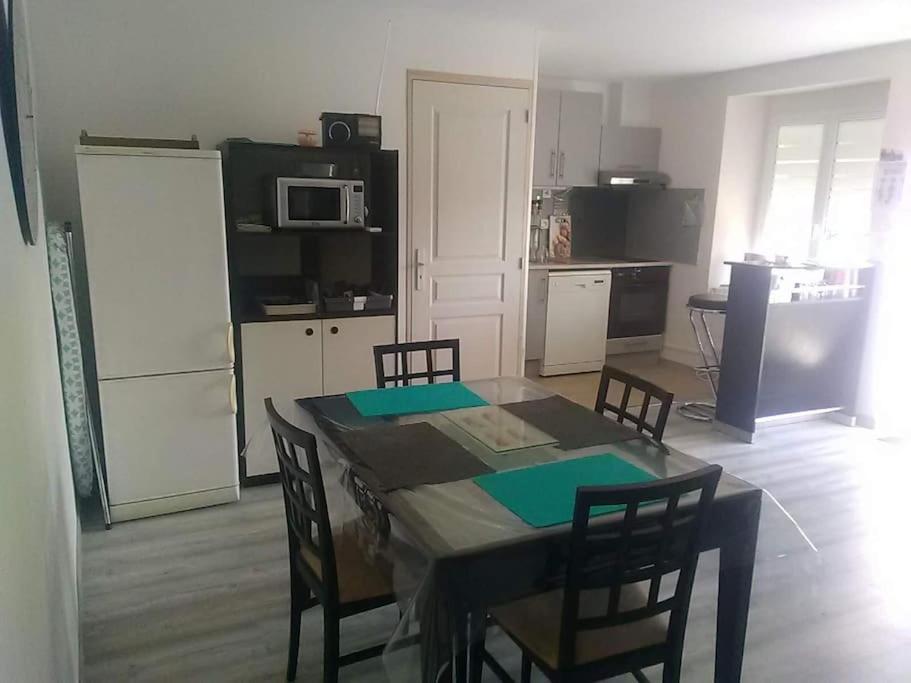 eine Küche mit einem Tisch und Stühlen im Zimmer in der Unterkunft Gîte familiale au cœur du village in Villiers-au-Bouin