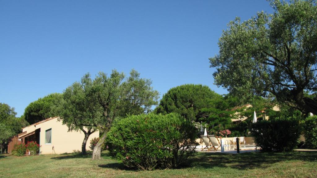 a house with a yard with trees and a house at Residence Les Sellettes in Saint-Tropez
