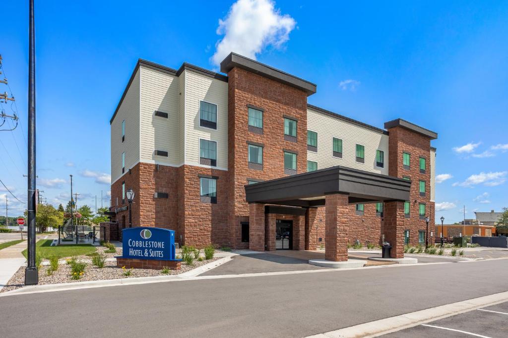 a brick building with a sign in front of it at Cobblestone Hotel & Suites - Lynden in Lynden