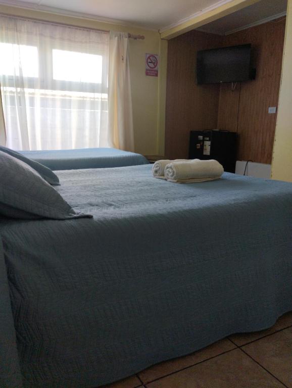 Una cama con dos toallas encima. en Sueños de lucio, en Coyhaique