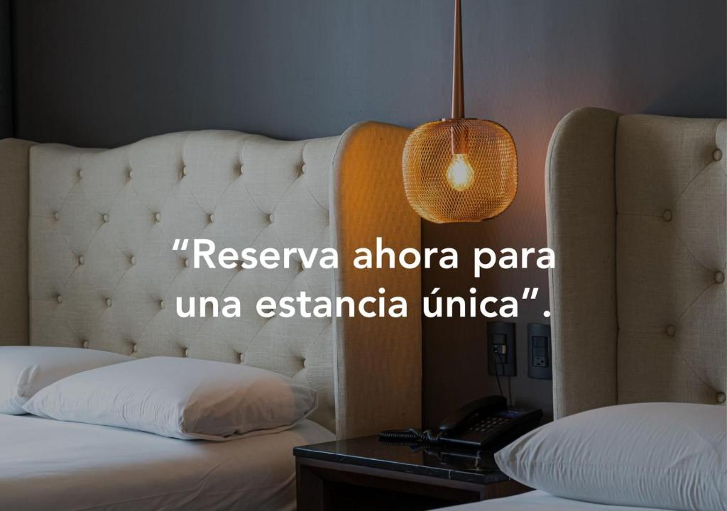 Habitación de hotel con cama y teléfono en Casa Basalto en Pachuca de Soto