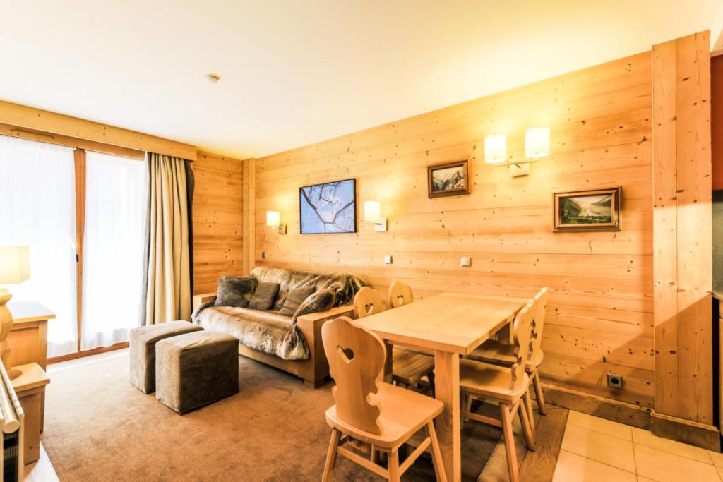 un soggiorno con tavolo e divano di Résidence Les Chalets du Forum - maeva Home - Appartement 2 pièces 6 person 30 a Courchevel