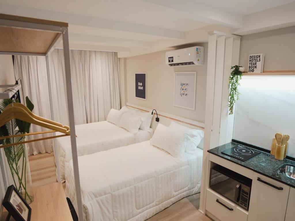 a small room with two beds and a television at Apê Pátio Paulista in São Paulo