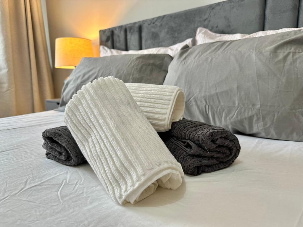 a pile of towels sitting on top of a bed at Urban Gateway in Central Birmingham in Birmingham