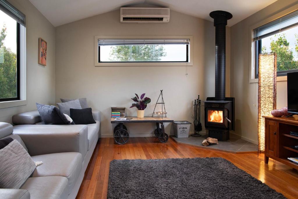 a living room with a couch and a fireplace at Alofi in Hepburn Springs