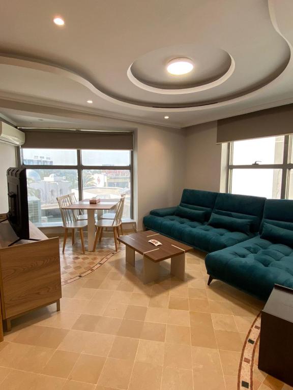 Crescent of the Lake Luxury Apartment في تونس: غرفة معيشة مع أريكة خضراء وطاولة