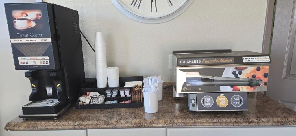 a counter top with a coffee maker and a clock at Value Lodge in Alpine