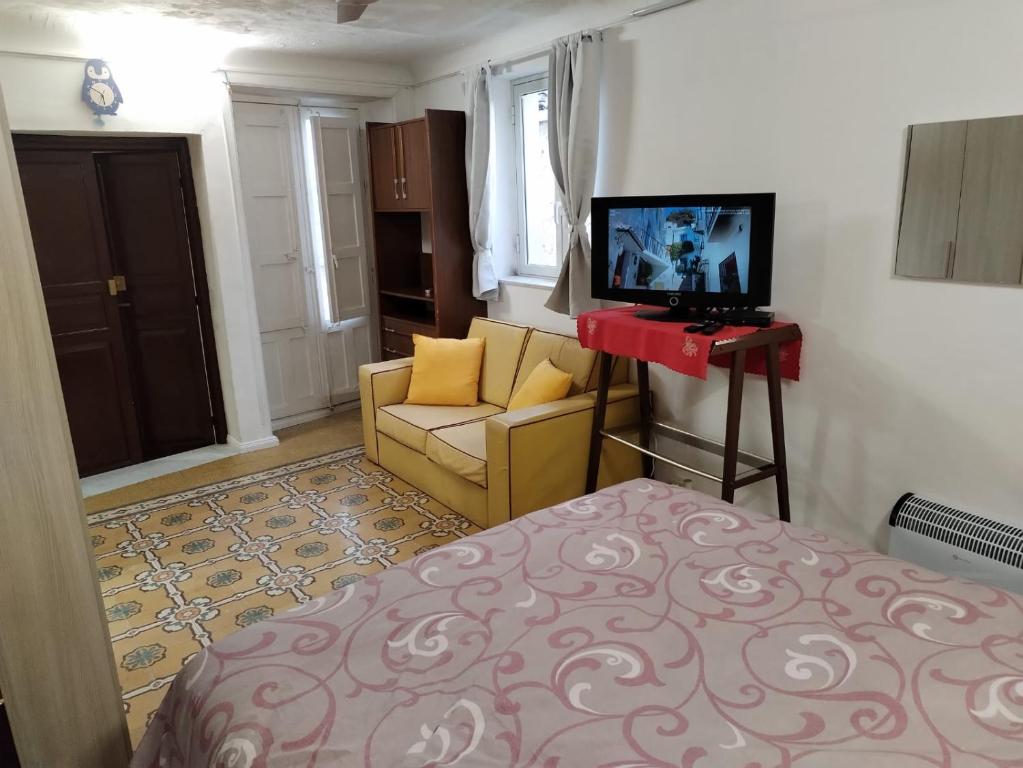 a bedroom with a bed and a television and a couch at Casa del Centro 2P in Santa Caterina Villarmosa
