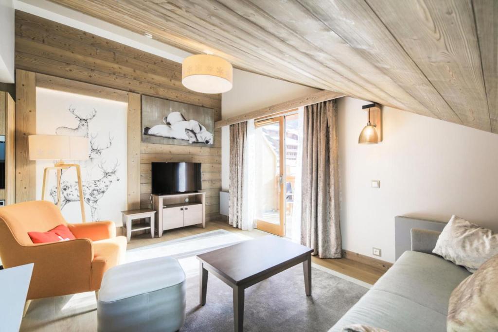 ein Wohnzimmer mit Sofa und Tisch in der Unterkunft Résidence Premium L'Hévana - maeva Home - Appartement Duplex 3 pièces 8 personnes Prestige MAE-9910 in Les Allues