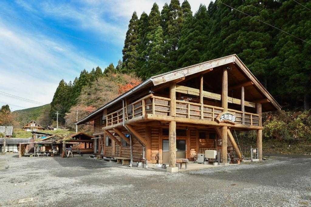 a large wooden cabin with a mountain in the background at Logland Okumino - Camp - Vacation STAY 42149v in Gujo