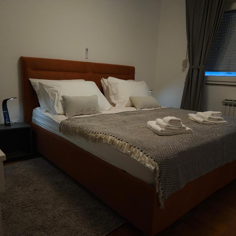 a bedroom with a bed with two towels on it at Apartman Dory in Zagreb