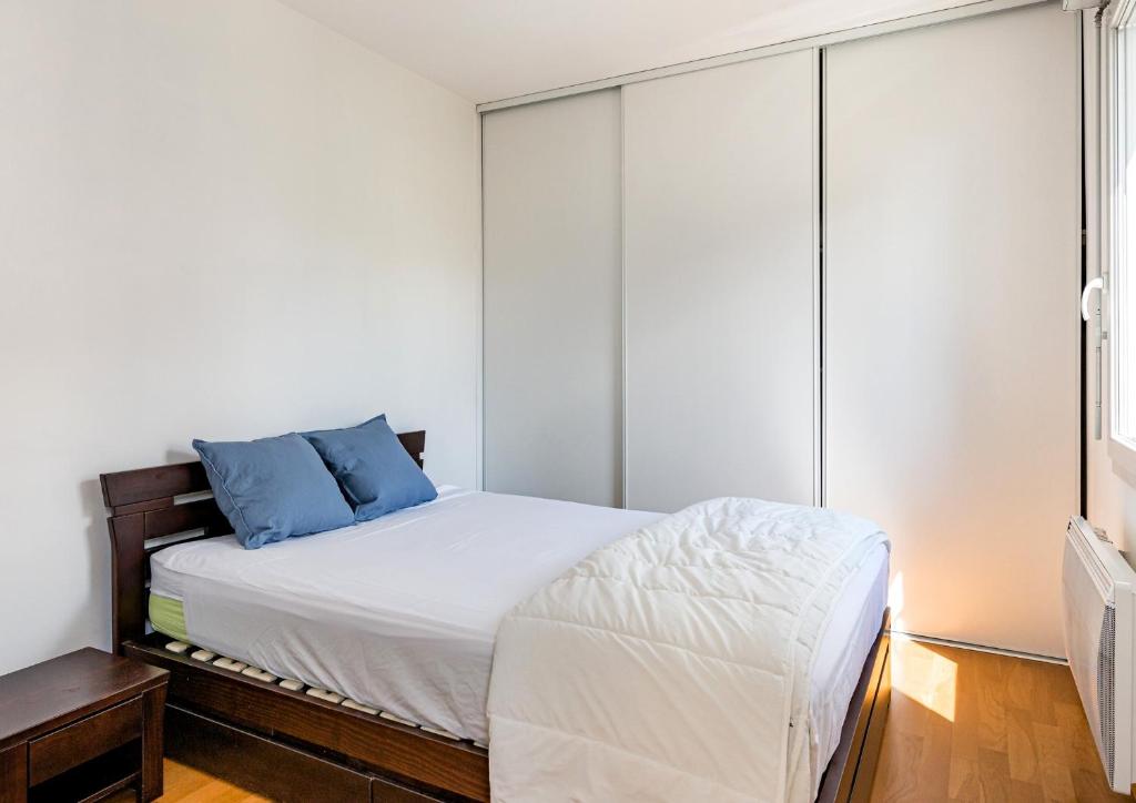 um quarto com uma cama com almofadas azuis em Le Bijou de Part-Dieu Grand et Charmant 2P Central em Lyon