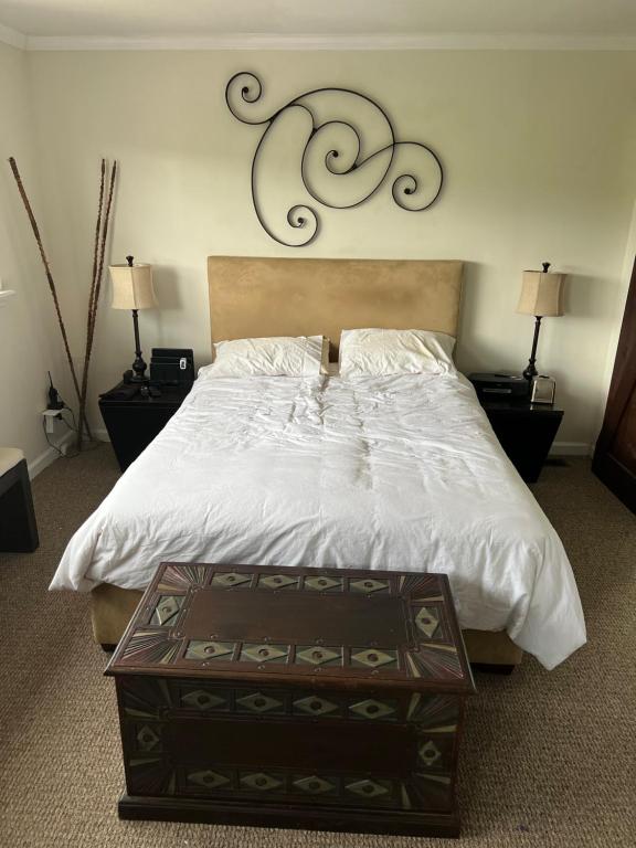 a bedroom with a large white bed with a wooden headboard at Multi room Oakland house 100 in Oakland