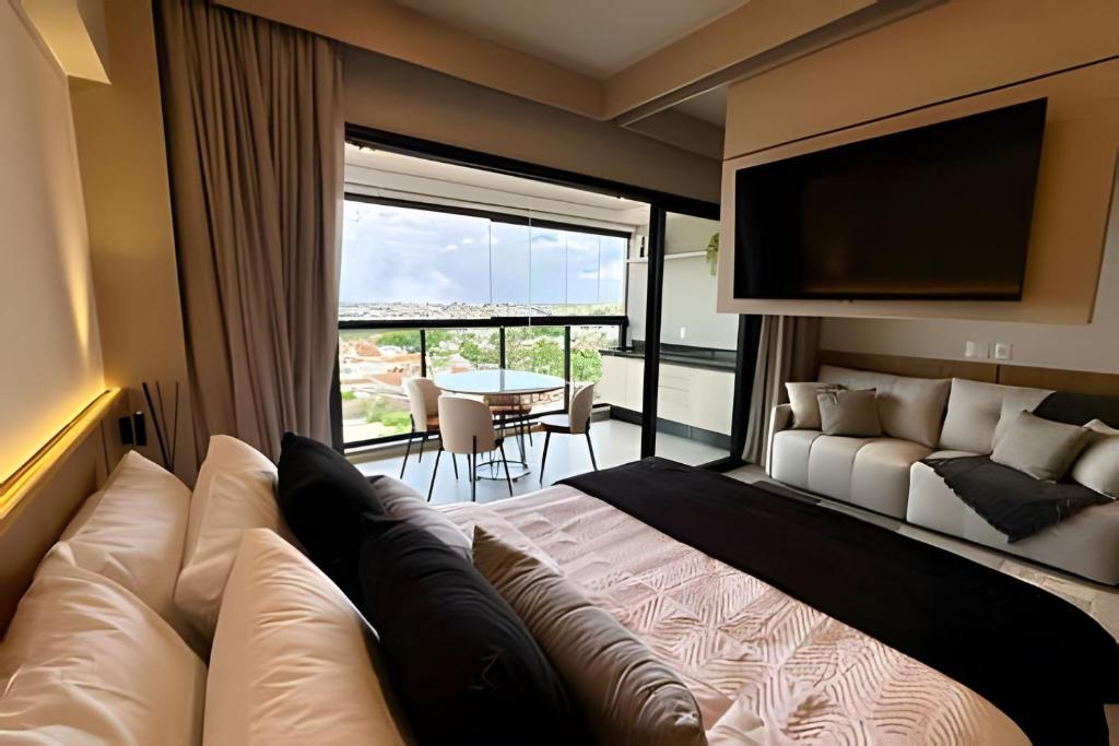 um quarto com uma cama grande e uma janela grande em Studio C9 de alto padrão em Marília