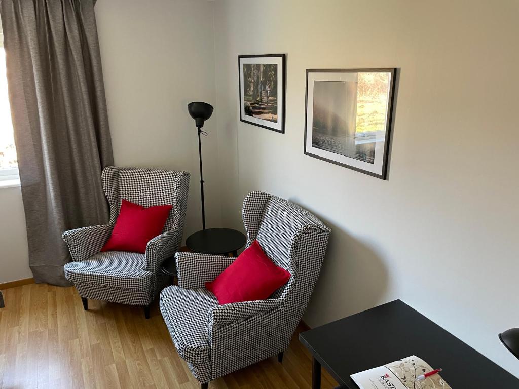 2 Stühle mit roten Kissen im Wohnzimmer in der Unterkunft Rasta Bromölla in Bromölla