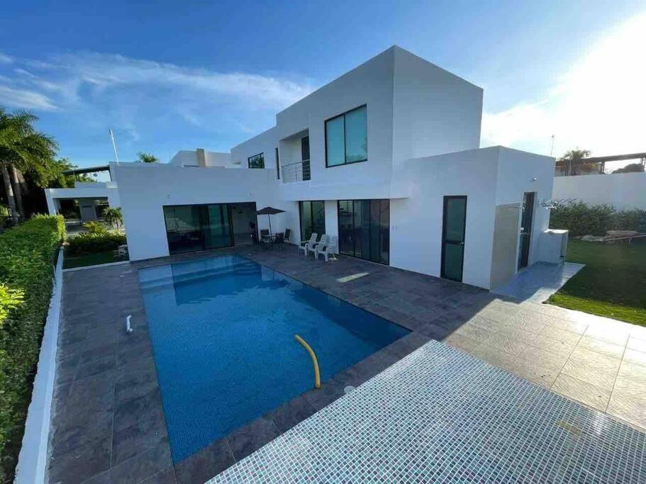 una casa blanca con piscina frente a ella en Casa con piscina privada Santa Ana, en Flandes