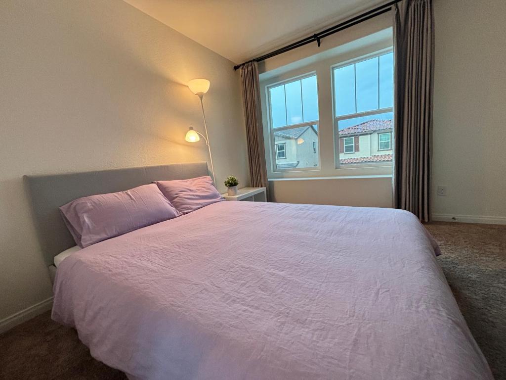 een slaapkamer met een groot bed en een groot raam bij kamiko‘s home in Ontario
