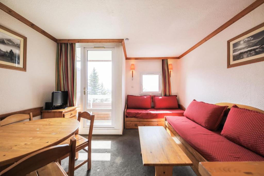 un salon avec un canapé et une table dans l'établissement Résidence Les Horizons d'Huez - maeva Home - Studio 4 personnes Confort MAE-7170, à Huez