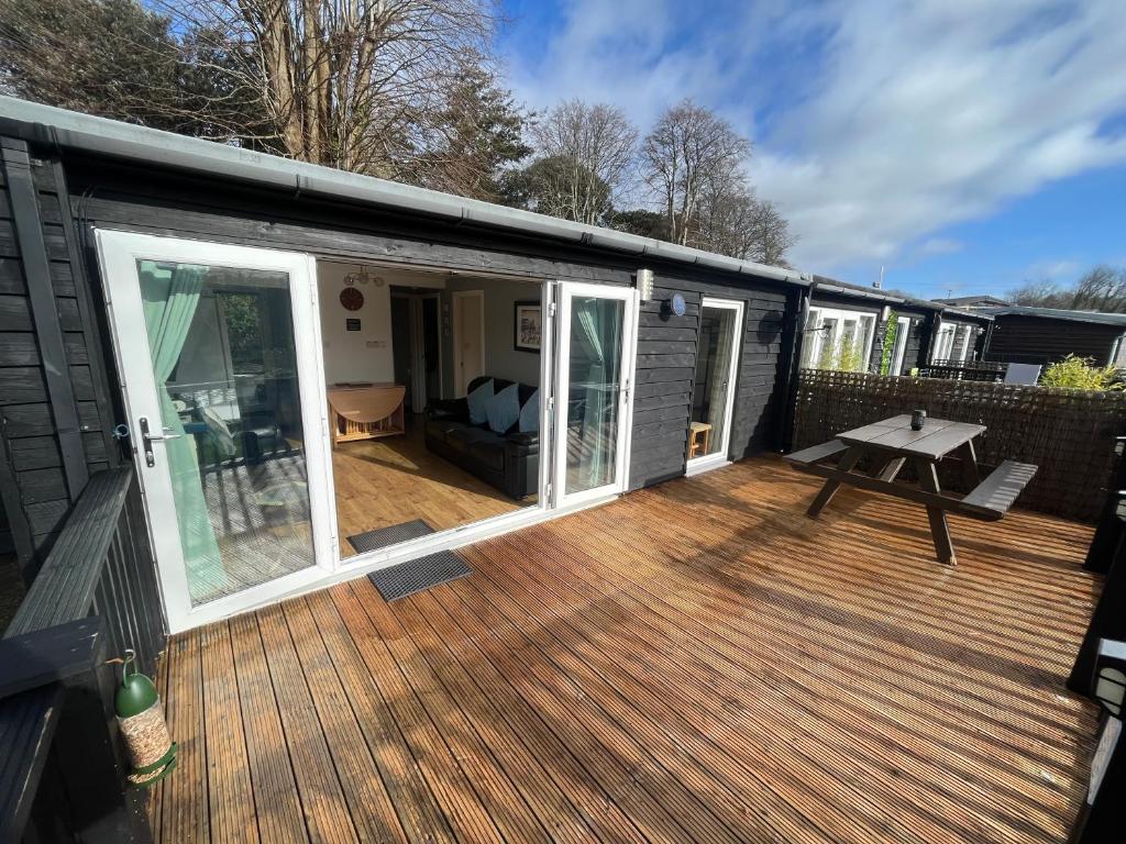 a screened in deck with a picnic table on it at Cosy North Wales 2 BEDROOM Chalet in Caernarfon