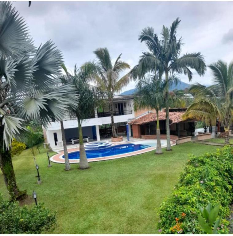 an exterior view of a house with palm trees at Finca luminosa in Pereira