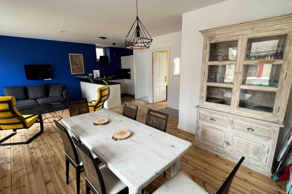 een eetkamer en woonkamer met een tafel en stoelen bij Séjour coloré et relaxant in Le Chambon-sur-Lignon