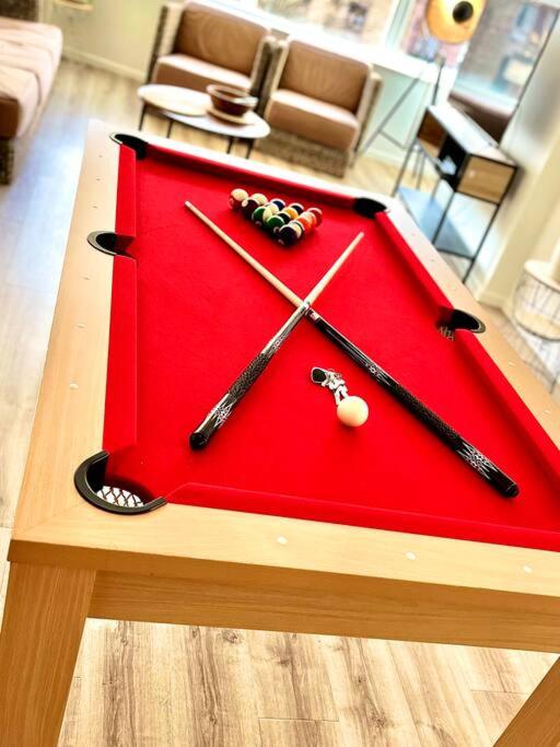 Une table rouge avec des équipements de base-ball en haut. dans l'établissement Le Milaz - Appartement classé 3* proche du lac - 8 personnes, à Thonon-les-Bains