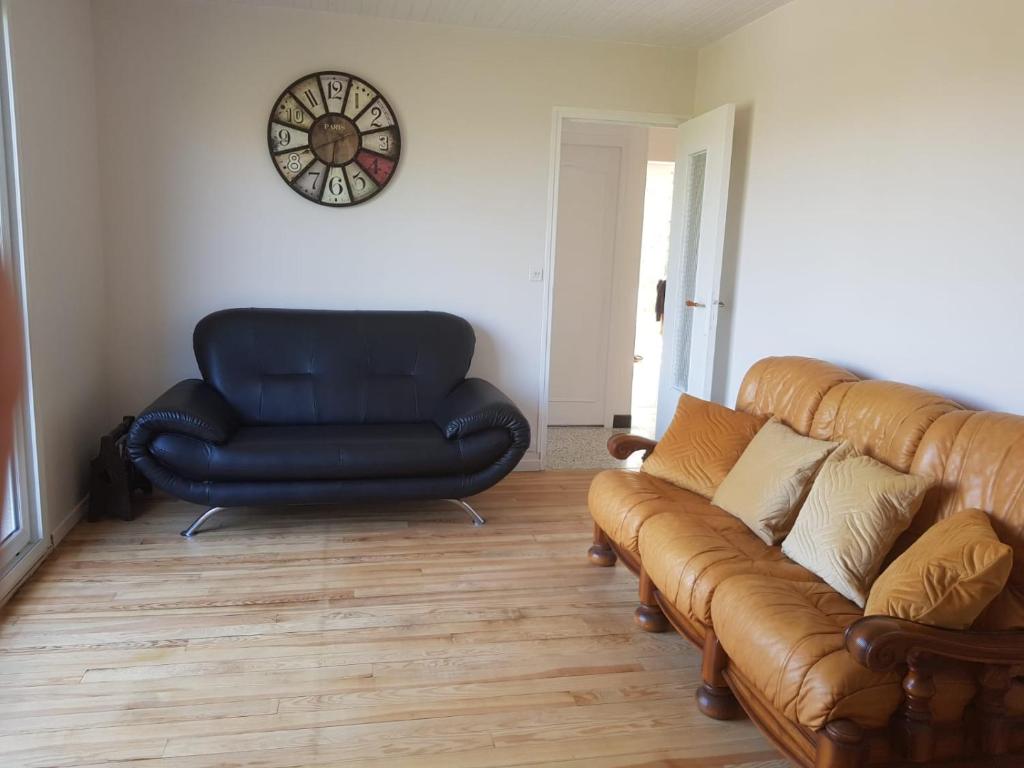 sala de estar con sofá y silla en Escapade entre mer et terre, en Berneval-le-Grand