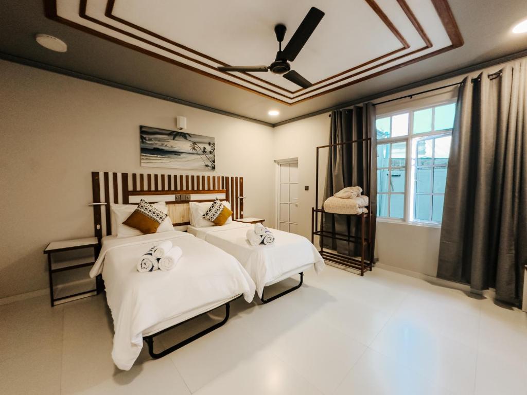 a bedroom with a bed with white sheets and a ceiling at Holiday home in Kamadhoo Island / Maldives in Kamadhoo