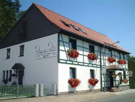 un edificio blanco con flores en las ventanas en Gästehaus Zum Felsenkeller, en Nordhausen