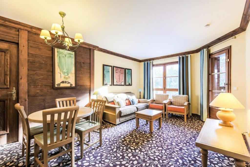 un salon avec un canapé, une table et des chaises dans l'établissement Résidence Les Arcs 1950 Le Village - maeva Home - Appartement 2 Pièces 4 Personnes - Sélection MAE-5479, à Bourg-Saint-Maurice