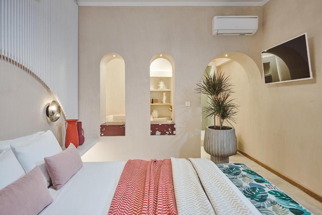 um quarto com uma cama branca e um vaso de plantas em Elyn House em Chania Town