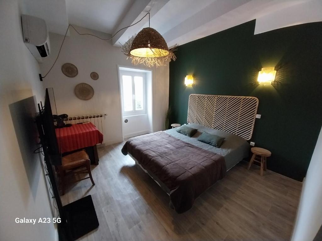 1 dormitorio con cama y pared verde en Le 18 by Benson, en Bollène