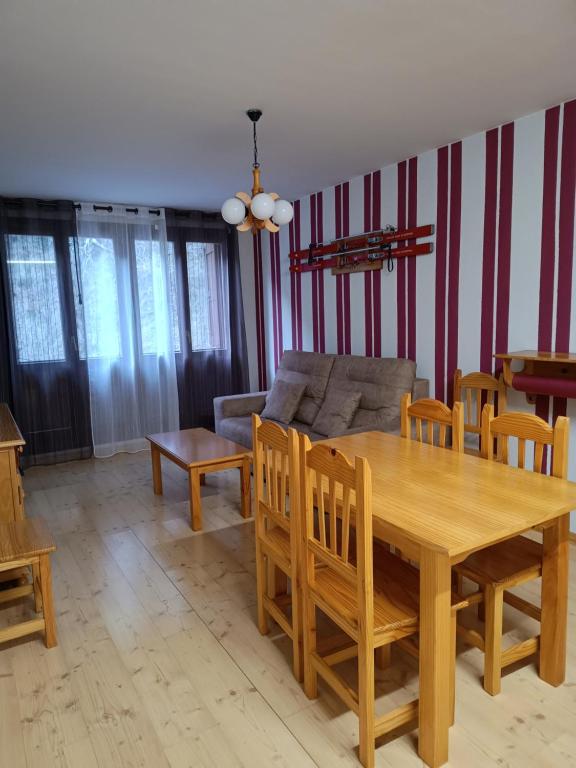 a living room with a wooden table and a couch at Apartamento Viman in Canfranc-Estación