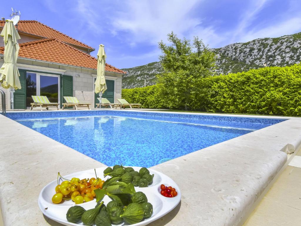 un plato de verduras en una mesa junto a una piscina en Holiday Home Villa Župa by Interhome, en Roglići
