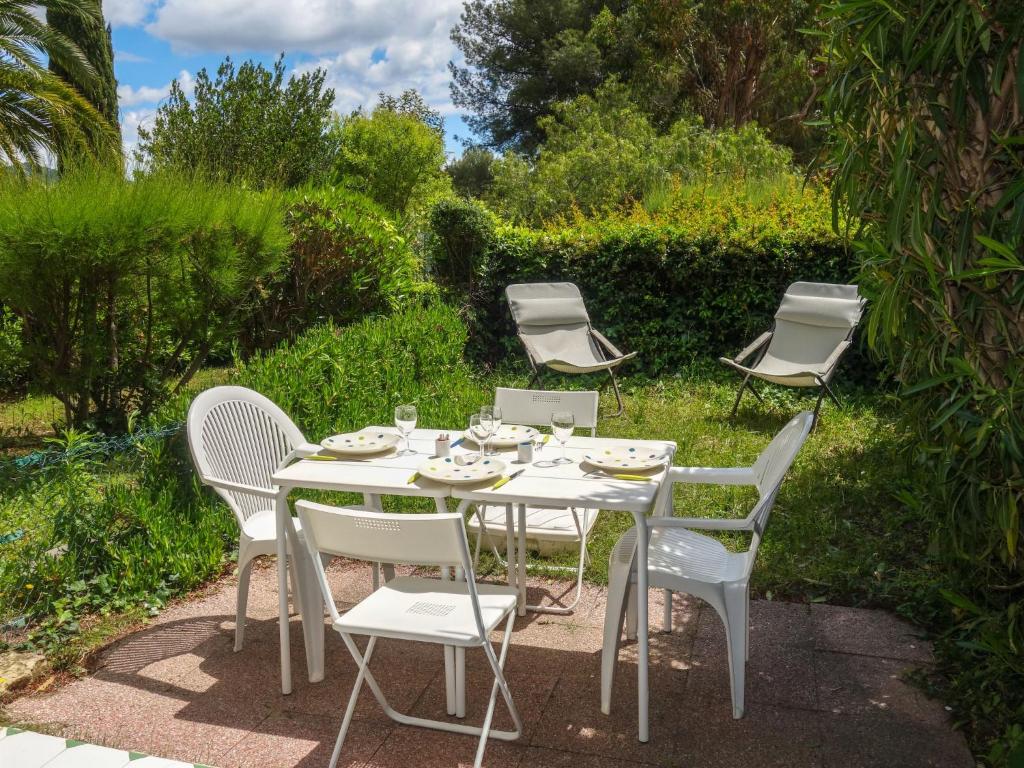 a white table and chairs in a garden at Apartment Jardins de la mer-10 by Interhome in Saint-Cyr-sur-Mer