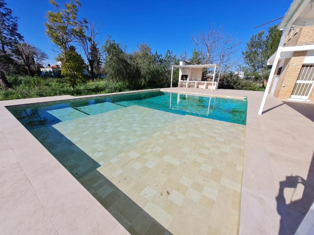 uma piscina em frente a uma casa em AMPLIO CHALET CON GENIAL PISCINA A 10 MIN DE SEVILLA em Alcalá de Guadaíra