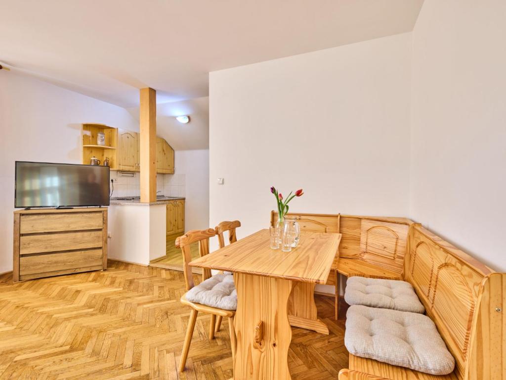 Il comprend une cuisine et une salle à manger avec une table et des chaises en bois. dans l'établissement Apartment Villa Belvedere-6 by Interhome, à Janské Lázně