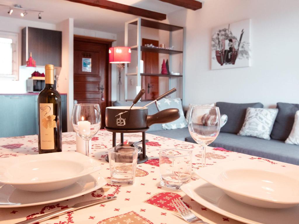 a table with a bottle of wine and glasses on it at Apartment Chantebrise A2 by Interhome in Chesières