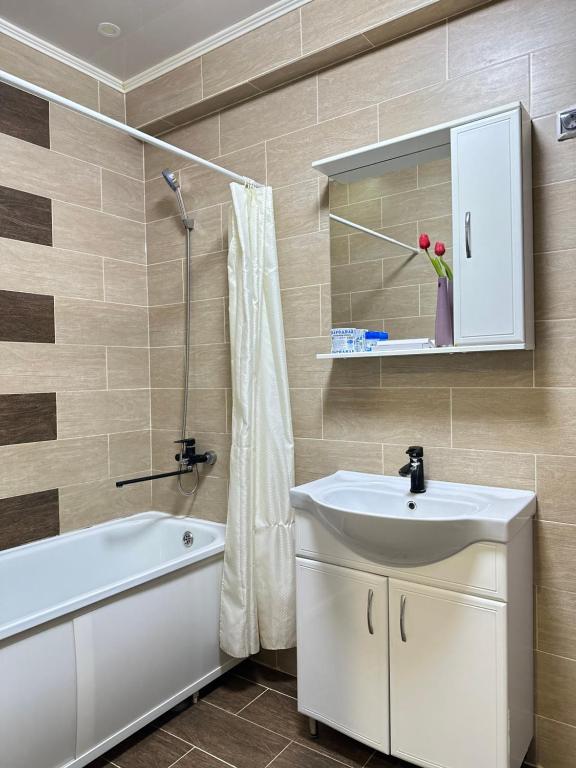 a bathroom with a sink and a tub and a toilet at ЖК Тыныштык in Aktau